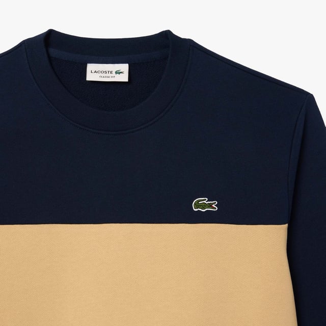 Color combination and graphics for a Lacoste dynamic and creative identity. Classic fit  natural ease on body with comfortable sleeves Our classic French terry Cut & sewn colorblock crew neck sweatshirt in mix of two different colors Rib at sleeves and bottom of body 3cm green crocodile at chest Lacoste wording 3D print at right sleeve.