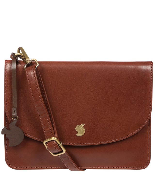 The 'Cara' cross body clutch bag from Conkca London is handcrafted from multi-toned leather for a beautiful finish. A magnetic press-stud secured cover opens to reveal the spacious interior that is lined with natural and untreated 100% cotton and includes two slip pockets. A full-width slip pouch on the rear of the bag is ideal for on-the-go storage. It comes with an adjustable leather strap with a maximum drop length of 70cm which is removable, converting the bag into a clutch bag. Adorned with the inimitable Conkca squirrel charm and metal logo.