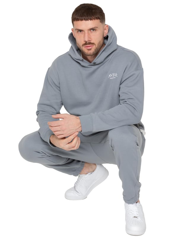 Presentamos el Conjunto de Chándal con Sudadera con Capucha Oversized Averè para Hombre de Enzo Milano, una mezcla perfecta de comodidad y estilo. Este set incluye una Sudadera con Capucha Oversized con un suave forro de felpa, un logotipo sutil en el pecho, un diseño audaz en la parte trasera y una capucha con botones a presión. Los Joggers de Corte Regular tienen una cintura elástica, cordones ajustables, bolsillos laterales y puños acanalados en los tobillos para un ajuste seguro. Ideal para relajarse o para salidas casuales, este chándal ofrece un estilo relajado y a la moda