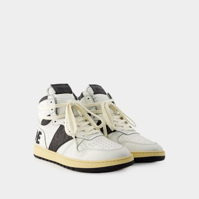 Presentamos las zapatillas Rhecess de Rhude, donde la frescura urbana se une a la comodidad contemporánea. Estas zapatillas fusionan a la perfección un diseño moderno con un guiño al estilo streetwear, mostrando una silueta única perfecta para ir a la moda statement. Para elevar tu look con estas zapatillas statement, considéralas la base de un conjunto moderno de inspiración callejera. Combínalas con unos vaqueros desgastados, una sudadera con capucha de estampado gráfico y unas gafas de sol atrevidas para conseguir un look vanguardista sin esfuerzo, perfecto para un día con amigos o una noche informal en la ciudad. Rhude Las zapatillas Rhecess de brand ejemplifican el compromiso de la marca con la calidad y la moda, ofreciéndote una opción de calzado distintiva y versátil que combina sin esfuerzo el encanto moderno con el estilo urbano. Sal con confianza, mostrando tu sensibilidad única por la moda y tu estilo de entrenador contemporáneo. Colores: Blanco - Blanco/Negro. Material principal: piel de ternero lisa. Material de la suela: caucho. Material del forro: algodón. Cierre: cordones en la parte superior. Forma de la punta: almendra. Ajuste: fiel a la talla - Talla: