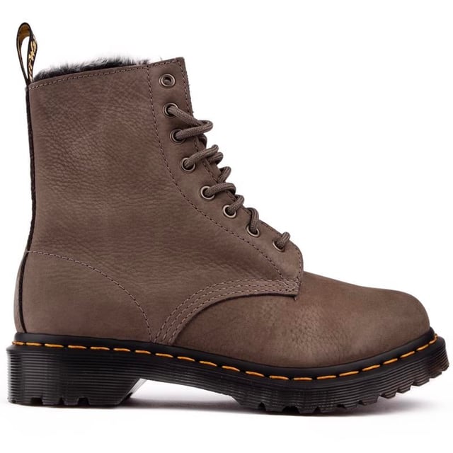 Botas grises con cordones Dr. Martens 1460 Serena para mujer. con una parte superior de cuero. con un sistema de cordones de 8 ojales y la firma AirWair en el talón. Estas botas altas para mujer tienen un suave forro de piel sintética. El inconfundible ADN del DOC como las icónicas costuras amarillas. Marca AirWair y suela Goodyear con amortiguación de aire y banda de rodadura resistente.