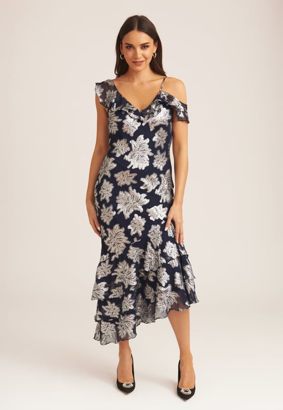 Saluda a este vestido midi con volantes florales imprescindible que es perfecto para cada ocasión. Si tienes una invitación para la boda de tu muñeca favorita, este vestido midi cumple todos los requisitos del código de vestimenta. Con un gran estampado floral y detalle de volante en el escote, ¿cómo podrías decir que no? Combina este vestido midi con tus tacones y tus accesorios favoritos para lograr un look que no pasará desapercibido.