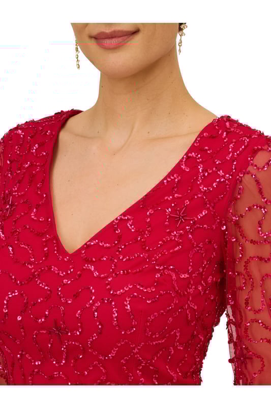 Ring in the evening with sparkle to spare in this playful sequin dress. This cocktail dress features a v-neckline, sheer long sleeves, and a soft skirt. Fully lined through the body, this long sleeve dress has a mesh overlay with swirls of sequin beading that is interspersed with clusters of tubed beading. A zipper back closure completes this beaded dress. Style this semi-formal dress with nude heels and a satin clutch to complete the look for a dressy night out or wedding guest duty.