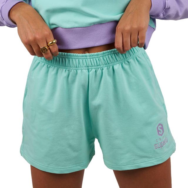 De #SuperbTotalLook waarmee je je op elk moment en in elke situatie jezelf kunt voelen. Een total look in pastelkleuren waarmee je je gelukkig kunt voelen en kunt genieten, zonder aan iets anders te denken, van de essentie van een felbegeerde zomer. Be Happy is de nieuwe Superb collectie voor elke dag, voor alle momenten. Be Happy is jezelf zijn, je vrij voelen.

 Kenmerken:

 Korte shorts met steekzakken
 Biezen in verschillende kleuren
 Schitterend geborduurd logo, voor een contrast van pastelkleuren
 Rubber in de taille
 Gemaakt en ontworpen in Barcelona door het Superb team
 Ons model Valeria is 1.69m lang en draagt maat S.

 Samenstelling:
 96% katoen
 4% elastaan
 Samenstelling: 96% katoen
 4% elastaan
 Onderhoud:
Wassen op maximum temperatuur 30º.
 Strijken op lage temperatuur.
 Je kunt een droger gebruiken.
 Geen bleekmiddel gebruiken.
