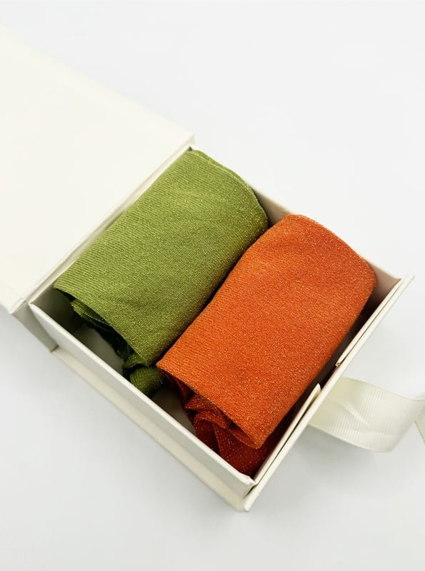 Get into the spirit of the season with this fun and vibrant glitter sock set by SVNX. Featuring two pairs in bold orange and green, they're perfect for adding a pop of sparkle to any outfit. Treat yourself or surprise someone special with a gift that combines style and festive flair! Knitted Glitter Socks Set. One size. 2 pairs. Gift Box. Cotton/Polyamide/Elastane. Wash at 40. Made in China