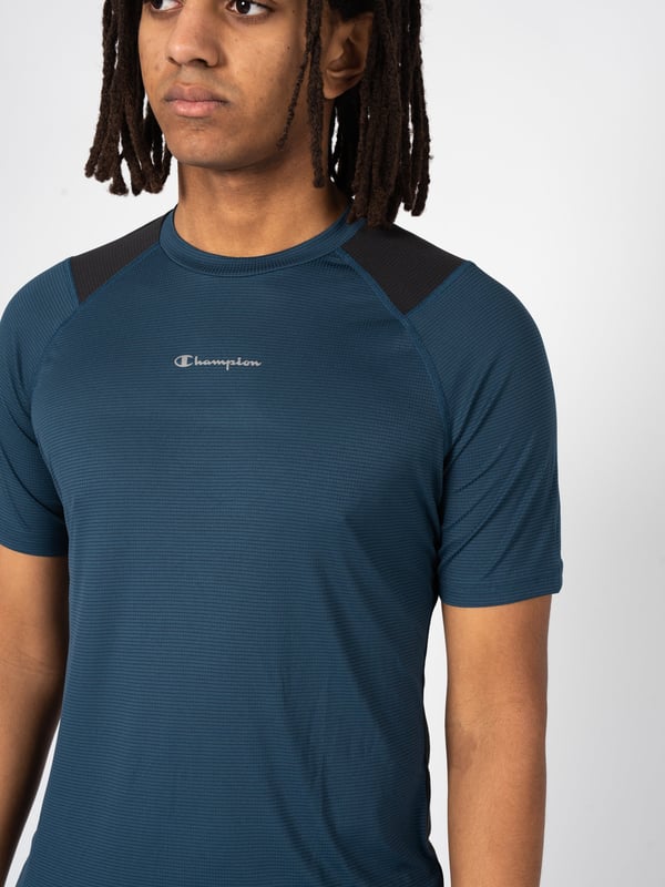 Deze klassieke, eenvoudige snit staat garant voor een tijdloze look en het gemak om het te combineren met verschillende stijlen.

De subtiele, ronde halslijn geeft het shirt een universele touch en zorgt ervoor dat het bij elk lichaamstype past door de nadruk te leggen op de nek en schouders.

Op de voorkant zorgt de print met de merknaam voor een modieuze en stedelijke look die ook een weerspiegeling is van het moderne ontwerp.

Gemaakt van hoogwaardig, ademend materiaal met een Quick Dry-systeem, biedt het de hele dag comfort, ongeacht de activiteit en de weersomstandigheden.