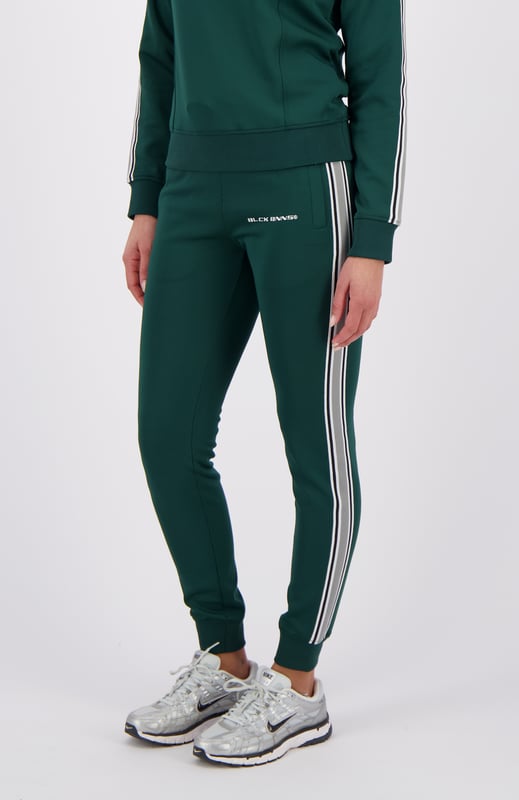 100% Polyester Elastischer Hosenbund mit Kordelzug Reißverschlusstaschen BLCK BNNS am rechten Bein Sportliches Streifenband an den Seiten Kombinierbar mit MIAMI TAPED TRACKTOP 