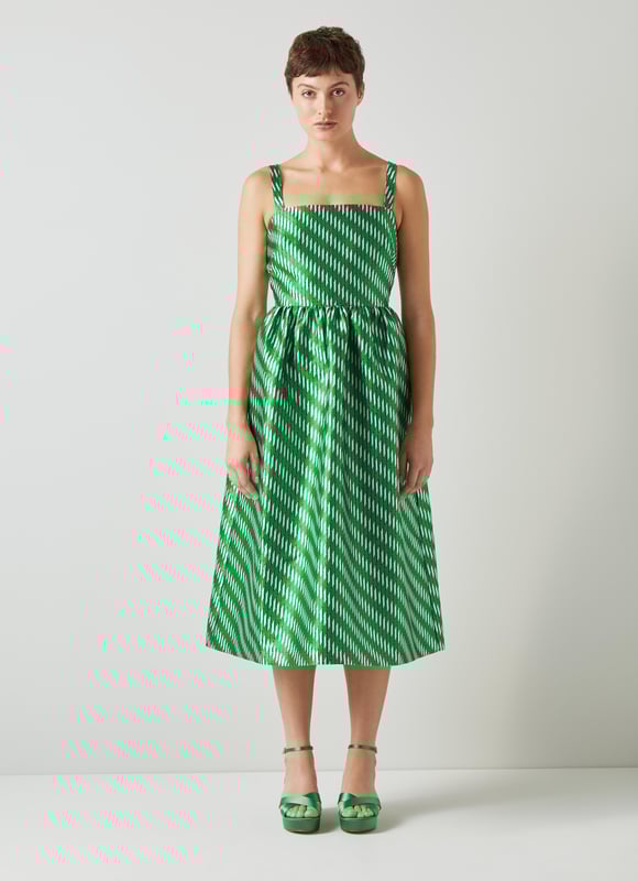 A dress that says 'belle of the ball', Elodie is a beautiful reimagition of our hero Olsen skirt, but in dress form. Crafted from voluminous, bouncy fabric with a green, black, white and metallic geometric weave, Elodie has a square neckline, slim shoulder straps, a gathered waist, side pockets and a puffy shape falling to just below the knee. Wear with green satin platforms to perfectly match, or style more casually with simple ballet flats - she's versatile, and very good fun.