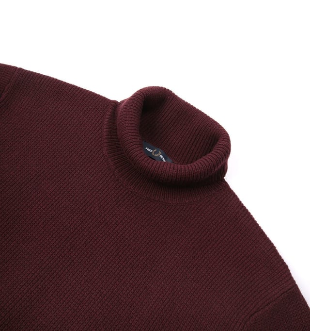 Taken directly from the Fred Perry archives  the Laurel Wreath Roll Neck Jumper is a recreation of a 1970's design knitted from ethically-sourced lambswool. Staying true to its original silhouette this head-turning jumper features a roll neck and ribbed trims. Finished with the iconic laurel wreath knit on the sleeve.-Relaxed Fit-Ethically-sourced Lambswool-Roll Neck-Long Sleeves -Ribbed Cuffs & Hem-Fred Perry Branding