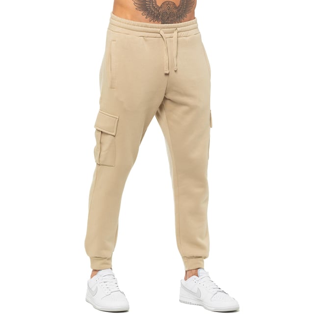 Enzo Mens Regular Fit Cargo Joggers. Features 2 Side Slash Pockets, 2 Cargo Pockets, Single Welt Back Pocket. Brushed Back Inner Fleece. Elasticated Waistband With Adjustable Drawstring. Cuffed Ankle. Features EZ Logo.