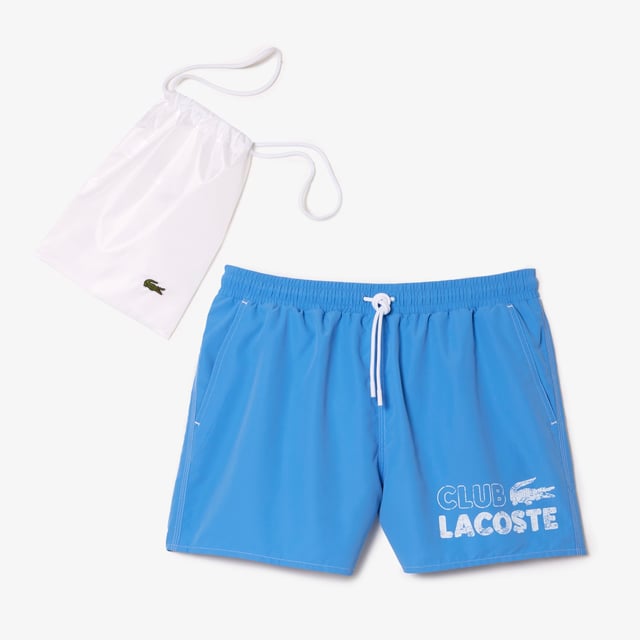 The essential swimwear of Lacoste wardrobe Short length short  mid-thigh when worn. Solid recycled polyester Quick dry Full elasticated waistband adjustable with drawcord and an integrated mesh boxer to ensure freedom and ease of movement in all circumstances. 2 hips side pockets 1 back piped pocket at right side when worn 1 inside hidden pocket at waistband with velcro Embroidered eyelets at waistband Branded drawstring 3 cm recycled tone on tone crocodile at back pocket Underpant thigh binding with Lacoste wording Contrasted white topstitches on garment Lacoste club vintage effect print on fornt left leg when worn Goes with a branded swimbag made of solid ripstop recycled fabric