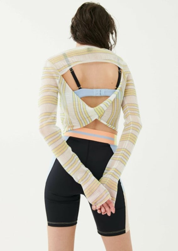 Fitted cropped knit top in a sheer shimmer fabrication. V-Neck button down front and a cut out twist detail at the back. P.E Nation logo badge on sleeve