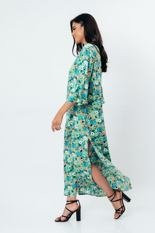 Deze zomerjurk in kaftanstijl met bloemenprint is gemaakt van geweven viscose. Het heeft een mandarijnkraag en een V-halslijn. De mouwen zijn lang met ruches aan de manchetten. De zoom heeft grote zijsplitten. Deze jurk heeft een lang, los, recht silhouet.