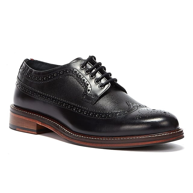Ben Sherman Archie Brogue Herren Schwarz Schuhe Ein raffinierter Schuhstil, der perfekt ist, wenn Turnschuhe einfach nicht ausreichen. Diese Brogues von Ben Sherman verfügen über ein hochwertiges Obermaterial aus Leder mit dekorativen Perforationen und einer traditionellen Brogue-Konstruktion mit Flügelspitze. Gesichert mit einem 5-Augen-Schnürverschluss und mit einer klassischen gestapelten Sohle mit Gummieinsatz abgeschlossen.