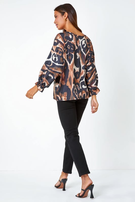 Abstract Print Blouson Sleeve Top from Roman. Elevate your casual collection this season with this luxurious woven top. Bringing a glamorous energy to your daytime style, this top is adorned in an abstract print that's filled with Autumnal hues making it perfect for the upcoming season. Designed with a round neckline which features a playful keyhole cut-out and full-length blouson sleeves that ooze feminine energy. Wear with smart trousers and heels for the perfect desk-to-dinner style.