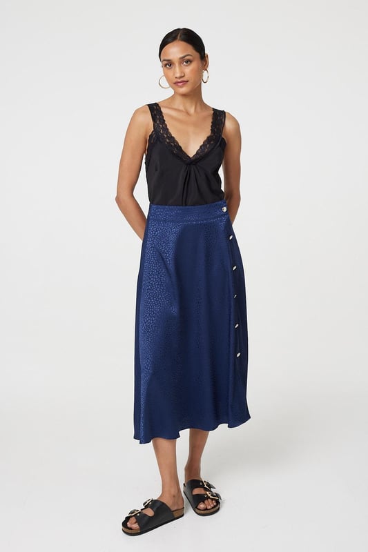 This elegant skirt has a silky satin texture with a flattering a-line cut. It fastens with button details and has a high waist fit, with a midi length hem. Tuck your favourite t-shirt, top or jumper into the waistband for an elevated casual look.