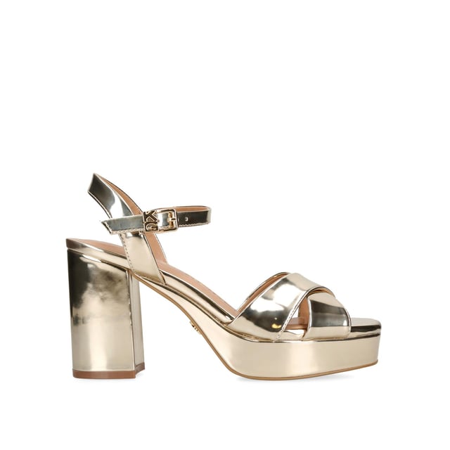 The Fenix heels feature a metallic gold upper with crossed strap over the toes. There is an adjustable ankle strap with KG Kurt Geiger detail. Heel height: 9.5cm. Platform height: 3cm. Pitch height: 6cm.