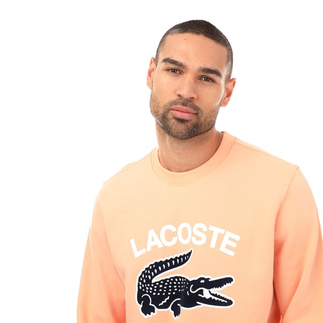 Men's Lacoste Crocodile Print Crew Neck Sweatshirt- Classic fit  natural ease:- Crew neck:- Lacoste lettering and oversised crocodile on front: - Embroidered crocodile on bottom: - Unbrushed cotton fleece: