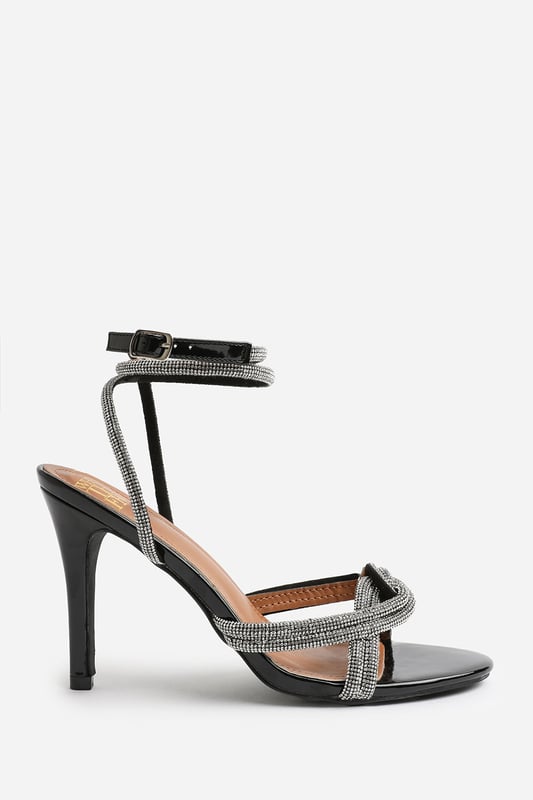 Introduce a touch of glamour to your footwear collection with our Adana Diamante Knot Detail with Cross Over Ankle Strap High Heels. These heels are the epitome of elegance and sophistication, making them the perfect finishing touch to any outfit, whether it's for a formal event, a night out, or a special occasion.

Key Features:



Exquisite Design: Enhanced by the diamante knot detail, these shoes are guaranteed to make heads turn.

Cross Over Ankle Strap: The cross-over ankle strap doesn't just lend a chic and trendy vibe, but also offers secure and comfortable fastening. Adjust the strap for a custom fit, ensuring these heels stay firmly in place.

High-Quality Construction: Crafted from premium materials, these high heels are designed to last. The high-quality construction ensures long-lasting durability while maintaining the comfort of your feet.


Specifications:


Material: Faux Leather
Closure: Ankle strap with buckle
Heel Height: 3.3' (8.3cm) approx

Invest in our Adana Diamante Knot Detail with Cross Over Ankle Strap High Heels and bring that extra touch of elegance and sophistication to your wardrobe. They speak loud and clear of luxury and style – a piece worth showcasing!