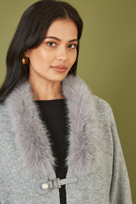 This cute cardi is perfect for cosying up this winter - In a soft marl knit with buckle fastening in the front and faux fur detachable collar. Style with jeans and a roll neck jumper - With boots or trainers for a casual off duty look.