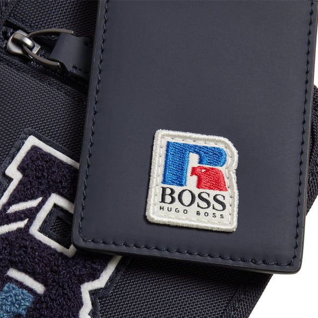 Men's BOSS x Russell Athletic Neck Pouch. A compact neck pouch with a detachable strap, by BOSS. Crafted in structured nylon made from 100% recycled fibers, this neck pouch is detailed with an exclusive logo. A branded hangtag with leather trims completes this accessory. The BOSS x Russell Athletic capsule unites signature style and expert craftsmanship with the aesthetic of an American sportswear icon, creating bold new designs for the next generation. Ref: 50465333410.