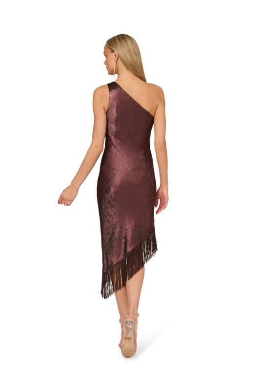 Shimmy into some sparkle and step out in this one shoulder fringe dress. This cocktail dress features a one shoulder neckline with a pleated design, fitted silhouette, and an asymmetrical mid-length skirt hem. Crafted from foiled chiffon fabric, this dress has no waist seam and is accented with metallic fringe at the hem. Cut on the bias for a figure-skimming look, this party dress has a side zipper closure. Styled with nude heels and metallic jewellery, this one shoulder dress will make any cocktail or formal event even more magical.