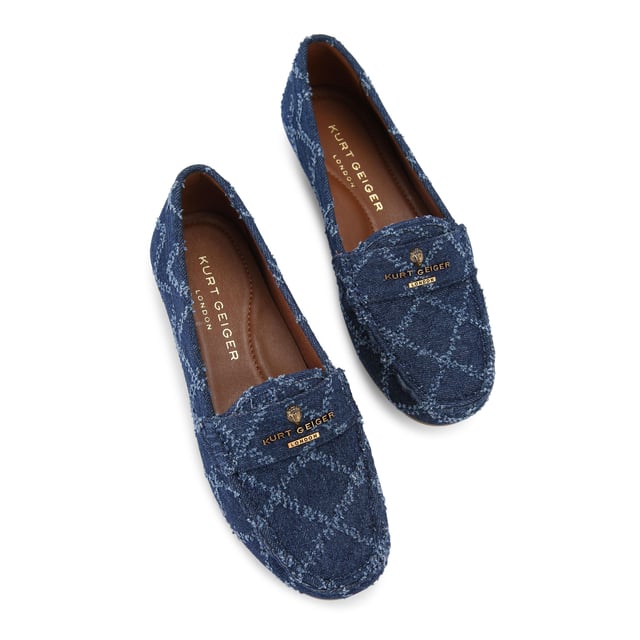 The Kurt Geiger Greenwich Moccasin slip-on loafer features a blue denim upper with frayed diamond quilting design. There is antiqued brass branding on the front alongside micro eagle head.