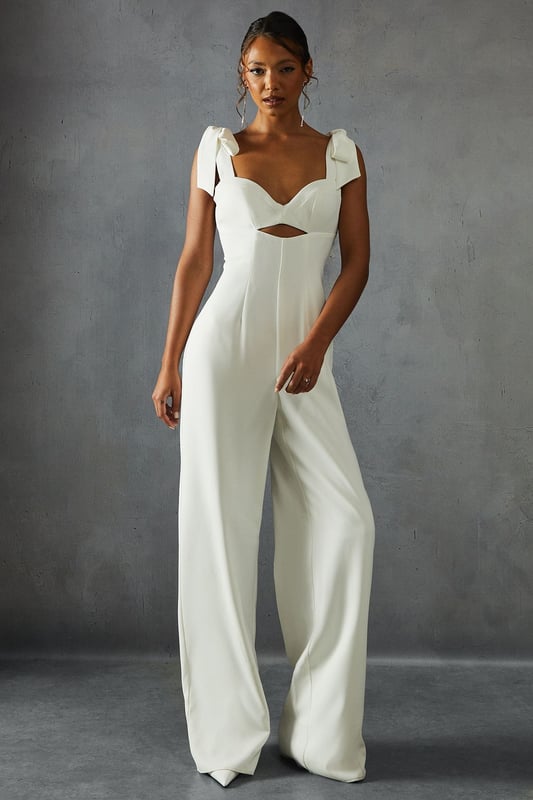 Striking bow shoulder detail for a feminine touch
        Flattering sweetheart neckline with alluring cut-out
        Wide leg silhouette for a dramatic, flowing look
        Square back design adds a modern twist
        Floor-length style perfect for formal occasions
    
    Make a statement at your next special event with this captivating wide leg jumpsuit from Misspap. The eye-catching bow shoulders lend a romantic flair, while the sweetheart neckline and subtle cut-out detail create an alluring silhouette. The wide-leg design flows gracefully to the floor, ensuring a dramatic entrance wherever you go. Style this showstopper with strappy heels and statement earrings for a red carpet-worthy look. Perfect for weddings, galas, or any occasion where you want to turn heads, this jumpsuit offers a fresh alternative to traditional evening wear. The square back adds a contemporary edge, making this piece a versatile addition to your formal wardrobe. Embrace your inner fashionista and let this jumpsuit be the centrepiece of your next unforgettable night out.