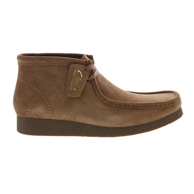 Las botas Clarks Wallabee para hombre en color marrón son una opción clásica y elegante para los hombres que buscan una combinación de comodidad, calidad y diseño atemporal. Clarks es famosa por su compromiso con la fabricación de calzado cómodo y bien hecho, y las botas Wallabee no son una excepción. Aquí tienes una descripción de las principales características:

 Color marrón intenso: Estas botas se presentan en un intenso color marrón, ofreciendo un aspecto cálido y versátil que complementa una amplia gama de atuendos, desde informales a semiformales. Las botas marrones son una opción clásica para los hombres.

 Parte superior de ante o piel de primera calidad:  Las botas Wallabee se fabrican normalmente con una parte superior de ante o piel de primera calidad, que proporciona tanto calidad como un aspecto elegante. La posibilidad de elegir entre ante y piel le permite seleccionar el material que mejor se adapte a su estilo y necesidades.

 Diseño inspirado en los mocasines:  Las botas Wallabee presentan un diseño inspirado en los mocasines, caracterizado por el distintivo pespunte de la puntera en forma de mocasín. Este diseño añade un toque de sofisticación y estilo a las botas.

 Cierre de cordones: Estas botas suelen tener un cierre de cordones, que permite un ajuste seguro y regulable. Los cordones añaden un aspecto atemporal y versátil.

 Suela de crepé: Las botas vienen con una suela de crepé, conocida por su comodidad y amortiguación. Proporciona una excelente absorción de impactos y reduce la fatiga, lo que las hace cómodas para un uso prolongado.

 Cordones clásicos de dos ojales:  El sistema de cordones de dos ojales es una característica clásica de las botas Wallabee, que se suma a su estilo tradicional y atemporal.

 Estilo versátil:  Las botas Clarks Wallabee marrones para hombre tienen un estilo versátil que puede combinarse con varios atuendos, lo que las hace adecuadas tanto para ocasiones informales como semiformales.