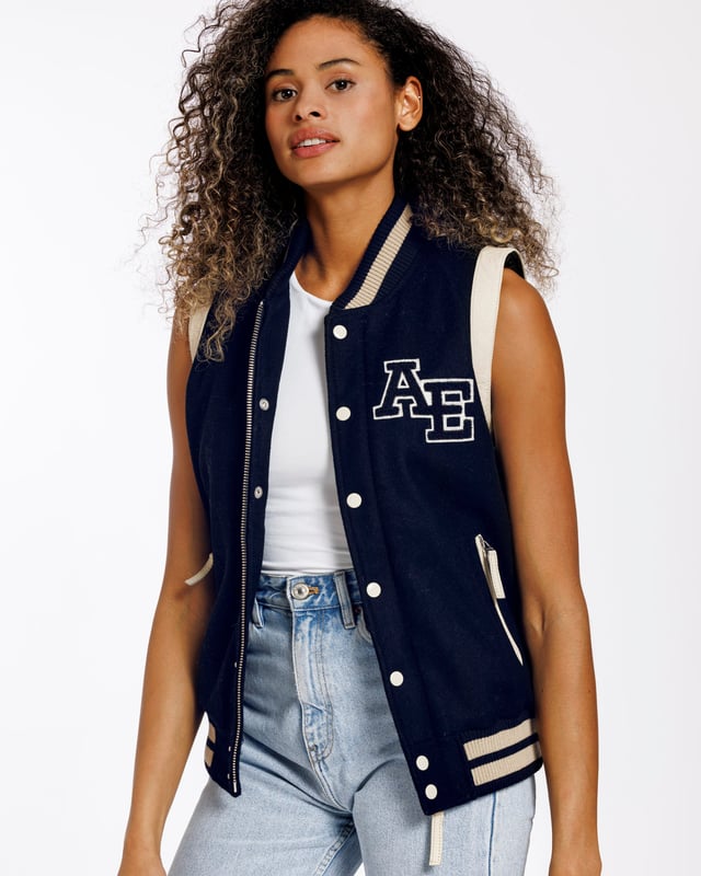 Een varsity gilet van hoge kwaliteit. Een moderne klassieker die altijd in stijl blijft. De jas is gemaakt van schapenwol. Aan beide zijden zitten ritszakken. De ritssluiting aan de voorkant van het jack kan worden gesloten met drukknopen.