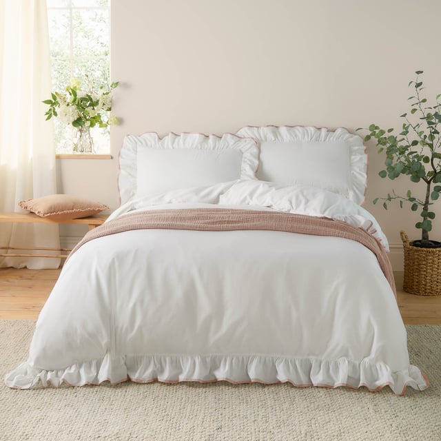 The Blousey Duvet Cover Set offers a simple yet elegant aesthetic, featuring a plain design crafted from soft, 100% cotton sateen. The look is elevated by a delicate ruffle trim and a contrasting piped edge, adding subtle sophistication. Perfect for layering with textured throws and cushions, this set creates a cosy yet fresh look.