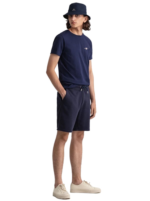 Gant introduces a mens t-shirt and shorts set with a small-scale embroidered shield graphic on the chest. Made of soft cotton and featuring a ribbed neckline, this tee showcases the iconic GANT logo. Crafted for everyday wear, the regular-fit tee is both comfortable and sustainable with Better Cotton. The included sweat shorts, also made of soft cotton blend, feature a ribbed waistband, three pockets, and a drawstring waist. The shorts are adorned with a small-scale embroidered shield graphic.