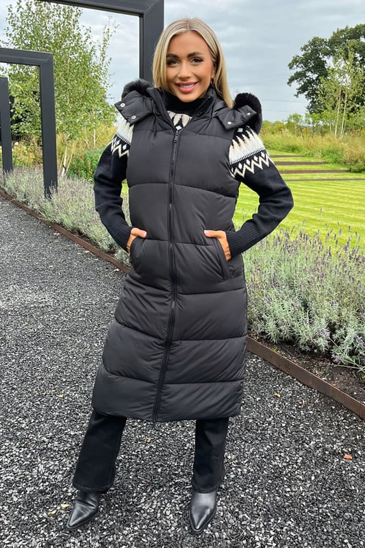 Feel cosy this winter in our Black Faux Fur Hooded Longline Padded
Gilet. Featuring a sleeveless design, a super soft black faux fur hood
with removable trim, all over padding, a double sided front zip and
front pockets.  Simply pair it with your favourite outfits to keep
warm and on trend this season.

Model wears: UK 8/ EU 36/ US 4
Model's height: 165cm/ 5'5"
Approx length from centre back to hem: 110 cm 
Fabric composition: 100% Polyester
Colour: BLACK
