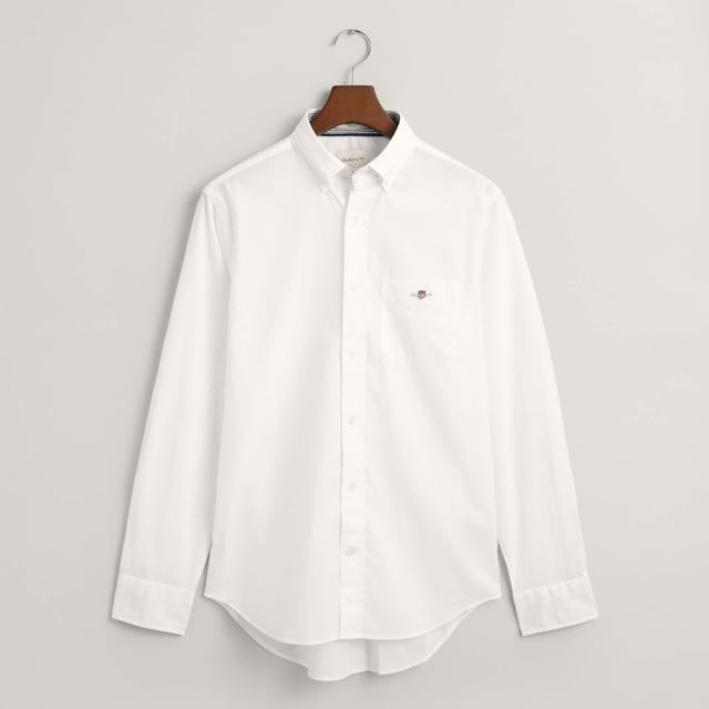 The shirt is made from durable poplin fabric  and is a true classic for your preppy wardrobe. Featuring a rounded hem and an embroidered 1980s-style GANT crest graphic on the chest pocket.