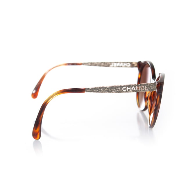 VINTAGE, RRP AS NEW
Chanel, round tortoise sunglasses with metal Chanel cut out temples in gold. The item is in good condition. The lenses have very light scratches and The temples are slightly apart (need adjustment). Comes with case and dust cloth.
 • CONDITION: good

• CODE: 5440

• MEASUREMENTS: height lens 5,5 cm, width lens 6 cm, width frame 14 cm

• MATERIAL: plastic, metal

• COLOR: brown, gold