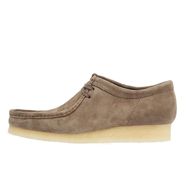These shoes feature suede uppers, flat laces, and tonal fobs, marking Clarks' commitment to quality. They are complete with natural crepe soles, ensuring both style and comfort.