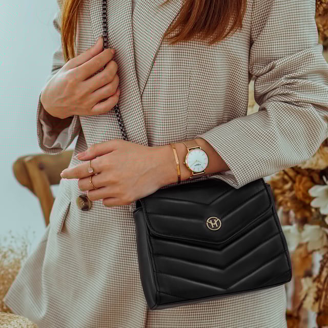 The New English Lady Bag in black is an absolute must-have. The classic black handbag can be combined in many ways and is the ideal companion for all situations in life. This bag from Victoria Hyde London also convinces with its high quality - made of genuine leather. In addition, it impresses with minimalist details - a golden logo plate, a quilted pattern in the leather and a black metal strap decorate the bag. The handbag can be worn over the shoulder as well as a crossbody bag.

Dimensions: 18.5cm x 14.5cm x 7cm
Carrying strap length: 95cm
Carrying strap height: 47cm
Texture: genuine leather