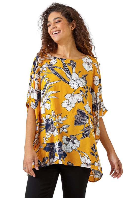 Floral Print Button Back Top from Roman. Add a light layer to your spring summer wardrobe with this short sleeve relaxed fit tee. Cut from a soft on the skin fabric, this boxy fit top is perfect for throwing on over your casual looks this season. Our large floral print top is finished with fabric covered buttons all down the back for added interest. Opt for white cropped trousers and sandals for your holiday ready ensembles.