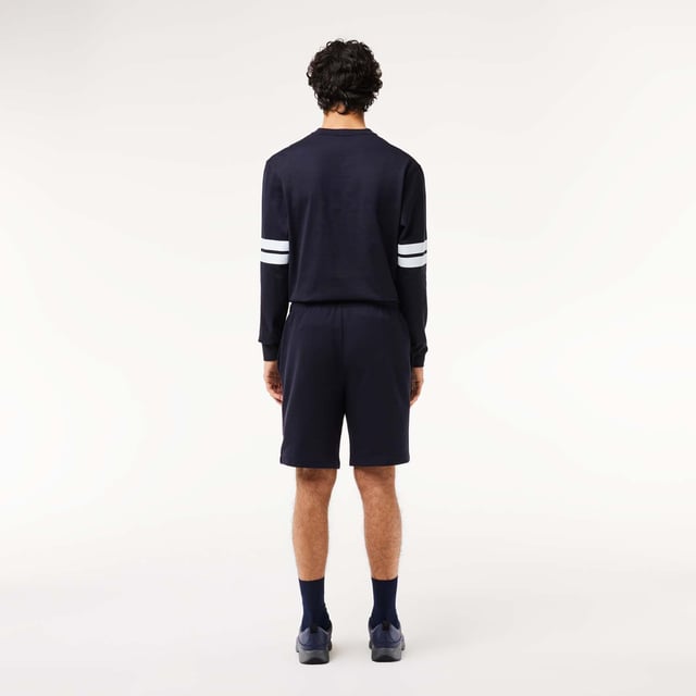 Own the french fashion sport The Joggers tracksuits : Comfort shape Regular fit  regular ease on body  hip and leg Shorts in our classic French Terry Climbing style drawcords 5cm puffed badge with silicone crocodile sewn at bottom Lacoste wording in flock print.