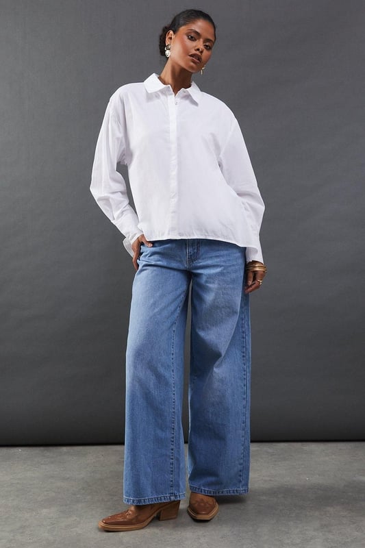 Striking open back design with tie detail
        Classic collared neckline for a polished look
        Long sleeves with button cuffs for versatility
        Relaxed fit through the body for comfort
        Crafted from breathable cotton poplin fabric
    
    Make a statement with this eye-catching poplin shirt from Warehouse. The open back design with delicate tie detail adds an unexpected twist to a classic silhouette, perfect for those who want to inject a bit of edge into their wardrobe. The relaxed fit and breathable cotton fabric ensure all-day comfort, while the collared neckline maintains a smart appearance. Style this versatile piece with your favourite denim for a casual daytime look, or dress it up with tailored trousers for a chic ensemble suitable for family gatherings or brunch with friends. The long sleeves can be rolled up for a more relaxed vibe, making this shirt adaptable for various occasions. Pair with flat sandals or trainers to complete your effortlessly cool outfit.
