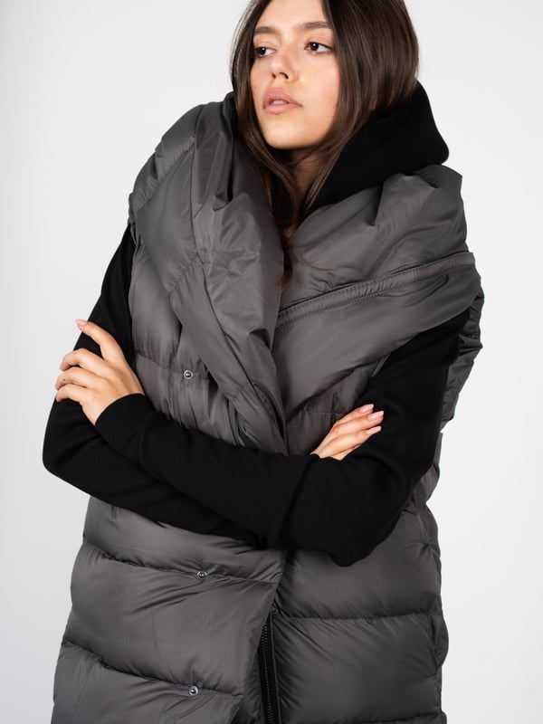 El color uniforme de nuestra chaqueta es la solución ideal para aquellos que valoran la elegancia y la simplicidad en sus estilismos diarios, además de la facilidad para combinarla con otros elementos del vestuario.

El diseño más largo proporciona no solo un confort excepcional y calidez en los días más fríos, sino que también añade a la silueta una apariencia esbelta y un acabado clásico, perfecto tanto para el uso diario como para ocasiones más formales.

El gorro, por su parte, es un agregado práctico que protege contra las condiciones climáticas adversas, y al mismo tiempo le da a la chaqueta un carácter moderno y deportivo.

Cerrada con cremallera y botones, la chaqueta sin mangas ofrece protección adicional contra el viento y el frío, además de permitir un rápido y cómodo ponerse y quitarse, lo cual es extremadamente práctico en el uso diario.

Fabricada en Italia, lo que garantiza la más alta calidad de los materiales y una fabricación precisa, característica de la artesanía italiana, famosa por su atención a cada detalle y excepcional habilidad artesanal.