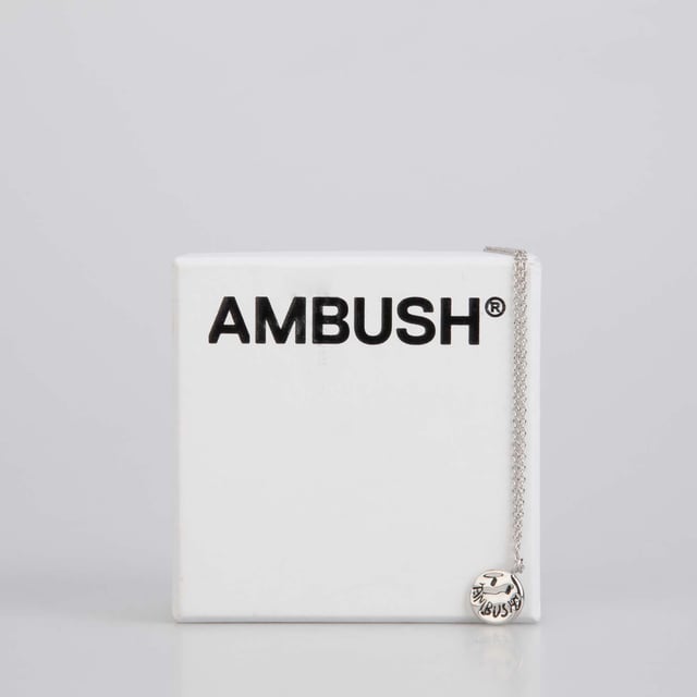 Ambush Smiley Charm Necklace in Silver.- Fine cable chain necklace in silver-tone brass.- Textured logo graphic pendant at drop.- Logo plaque at adjustable lobster-clasp fastening. Material: 100% Brass. Ref: BWOB0710017200.