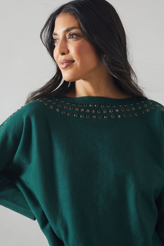 Boat neck design for a sophisticated silhouette
        Stud detailing along neckline and shoulders for added glamour
        Relaxed fit through the body for comfort
        Long sleeves for versatile styling
        Ribbed cuffs and hem for a polished finish
    
    This Wallis jumper seamlessly blends comfort with sophistication, making it a versatile addition to your wardrobe. The boat neck design creates an elegant neckline, while the stud detailing adds a touch of glamour to elevate your look. Perfect for casual events or family gatherings, this jumper can be styled effortlessly for various occasions. Pair it with sleek trousers and ankle boots for a chic daytime ensemble, or dress it up with a statement necklace and heels for evening drinks. The relaxed fit ensures all-day comfort without compromising on style, allowing you to feel at ease whether you're running errands or enjoying a leisurely brunch with friends. This jumper is a testament to Wallis' commitment to creating pieces that are both fashionable and functional, catering to the modern woman who values both style and comfort in her everyday attire.