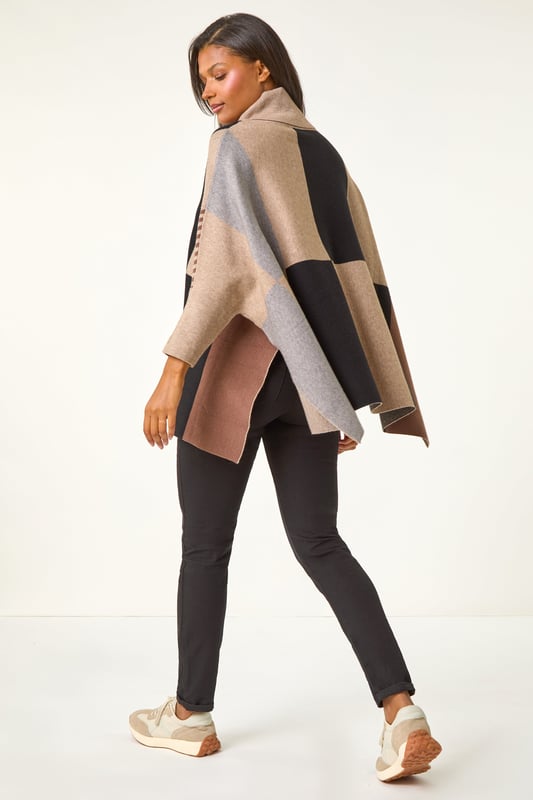 Check Colour Block Knit Poncho from Roman. This style is ONE size.  Stay snug and stylish in our cosy check colour block knit. Crafted from a soft knit fabric, this poncho-shaped jumper features a trendy check contrast pattern. Designed with a flattering roll neckline and long sleeves, this knit is perfect for the Autumn Winter season. Pair with jeggings and ankle boots for a classic fall look that will keep you warm all day long!