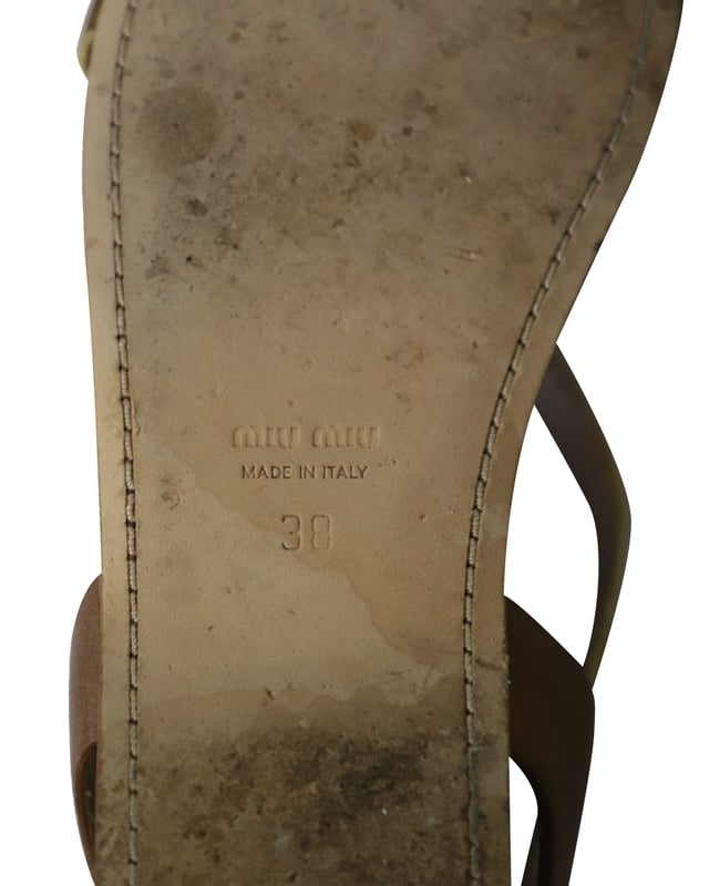 VINTAGE, UVP WIE NEU  
Das goldene Riemen-Detail kennzeichnet diese Gladiatorensandalen von Miu Miu. Hergestellt aus Leder, können diese Gladiatorensandalen dich überall hin begleiten und lassen sich perfekt mit deinen Lieblingsjeans kombinieren. Stylen Sie diese Sandalen mit einer Jeans und einem T-Shirt und sehen Sie dennoch entspannt schick aus.  

Miu Miu Gladiator Flache Sandalen aus goldfarbenem Leder  
Zustand: Gut, kommt mit Schuhkarton  
Abnutzungserscheinungen: Starke Abnutzung an der Sohle und Falten im Leder  
Material: Leder  
Größe: 38/US8  
SKU: 159856  