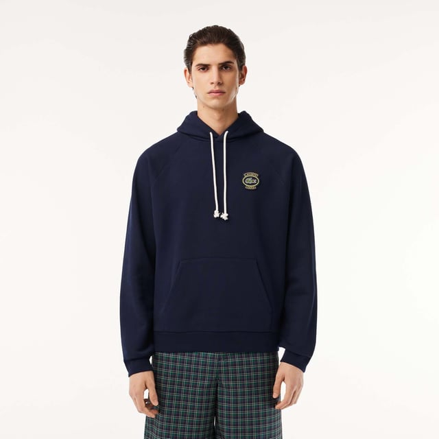 Own the french fashion sport Hoodie in French Terry Raglan sleeves Kagaroo pocket Knot drawcord 55x53 cm felt badge with Lacoste Paris embroidery and green crocodile on chest.