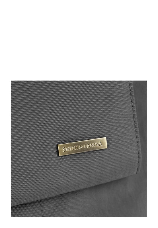 Made from our signature nylon, the Portrait Nylon Tote is the perfect way to carry all your everyday essentials. Featuring a padded carry handle and adjustable crossbody strap with a clip off function. Features: , Zip top opening, Front oversized flap over zip pocket, Rear zip pocket, SMITH & CANOVA antique brass logo, Branded antique brass zips, Padded grab handle, Adjustable crossbody strap (detachable), Internal 15 inch padded laptop sleeve, Internal zip pocket, 2 Internal mobile phone slip pockets - fits normal and plus size smart phones, 2 Internal pen slip pockets Style Ref: 92682 DKGREY