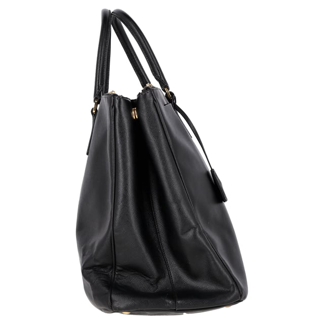 VINTAGE, NEUPREIS WIE NEU  
Die Prada Double Zip Executive Tote Bag aus schwarzem Saffiano Lux Leder ist ein elegantes und vielseitiges Accessoire. Hergestellt aus strapazierfähigem und luxuriösem Saffiano-Leder, vereint diese Tote praktische und stilvolle Eigenschaften und bietet ausreichend Platz für alle Ihre täglichen Essentials und mehr. Mit ihrem schlanken Design und funktionalen Merkmalen, einschließlich zweier Außentaschen mit Reißverschluss und einem großen Hauptfach, ermöglicht diese Tasche eine bequeme Organisation Ihrer Sachen. Abgerundet mit einer schicken Clochette und einem Schlüsselring-Detail ist diese Tasche der perfekte Begleiter für den Alltag und kombiniert mühelos Eleganz und Funktionalität.

Prada Double Zip Executive Tote Bag aus schwarzem Saffiano Lux Leder  
Zustand: Ausgezeichnet  
Abnutzungserscheinungen: Kein Einzelhandelsetikett, keine sichtbaren Gebrauchsspuren,  
Verpackung: Keine  
Farbe: schwarz  
Material: Leder | Saffiano-Leder  
Größe: Einheitsgröße  
Maße: Breite: 180; Höhe: 300; Länge: 420; Henkelabfall: 130; Gurtlänge: 300  
SKU: NAPPUGBBA399031W