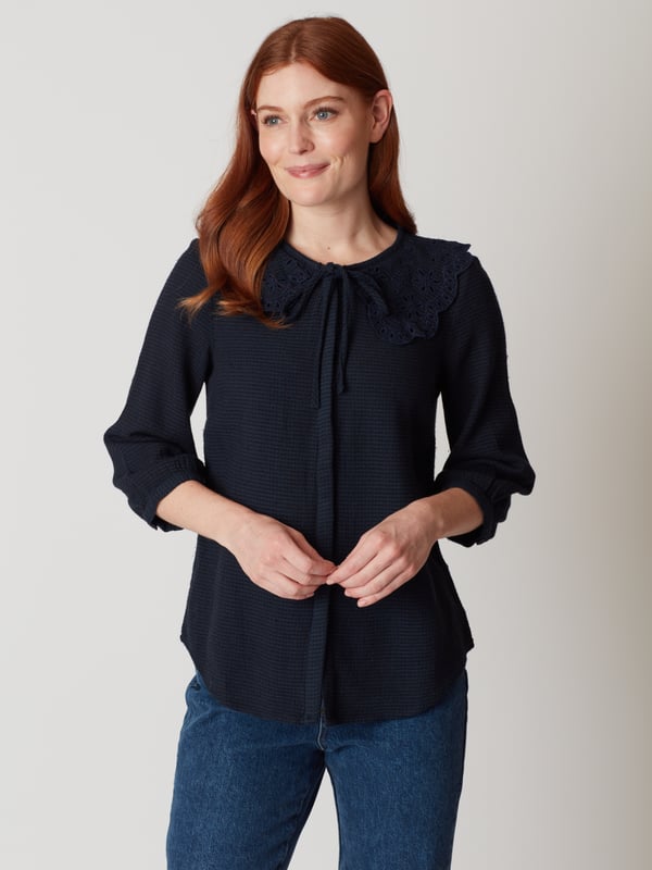 Discover the classic elegance of the Gale Collar Blouse, perfect for elevating your everyday style. Crafted from a soft cotton blend, featuring a textured weave and exquisite embroidered collar, this navy blouse is ideal for day-to-evening wear.