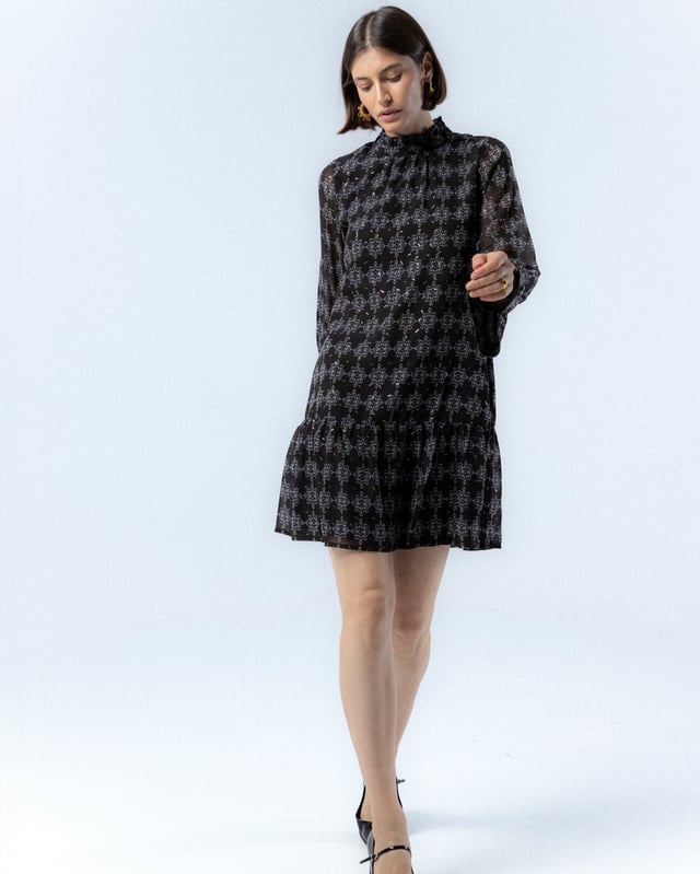 El vestido con volante Catalina en azul te hará sentir la frescura del invierno. Con su diseño elegante y detalles de volantes, esta prenda añade un toque de sofisticación y movimiento a tu look. Perfecto para cualquier ocasión, realza tu silueta con su lazada en la cintura.
 
 
 
 Vestido corto con cuello redondo. 
 
 Manga larga con puño elastico y volante a la altura del codo. 
 
 Cierre en espalda con cremallera. 
 
 Tejido estampado geométrico con detalles de foil dorado.